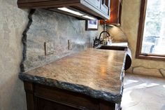 a kitchen with marble counter tops and wooden cabinets