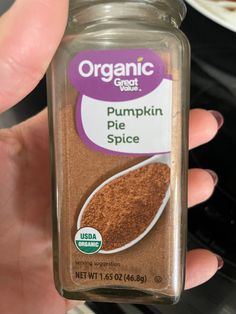 a hand holding a jar of pumpkin pie spice