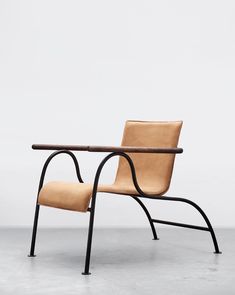 a chair that is sitting on some kind of metal frame with a leather seat and backrest