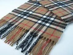 a brown and black plaid scarf with fringes on white table top next to other items