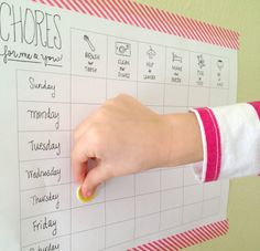 a person's hand writing on a white board with the words chores written on it