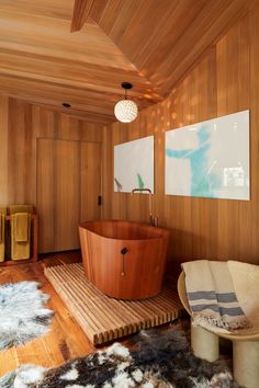 a large wooden bath tub sitting in the middle of a room next to a chair