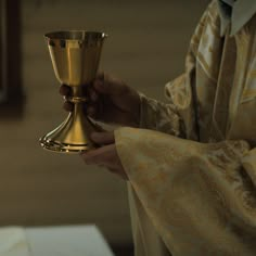 a priest holding a golden cup in his hands