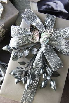 a gift wrapped in silver paper with a bow