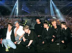 the group of boys are posing for a photo in front of an audience at a concert