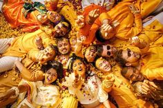 a group of people laying on top of each other in the middle of yellow petals