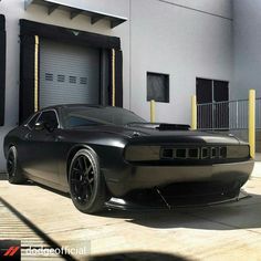 a black sports car parked in front of a garage