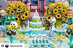 a table topped with cakes and cupcakes covered in frosting next to fake sunflowers