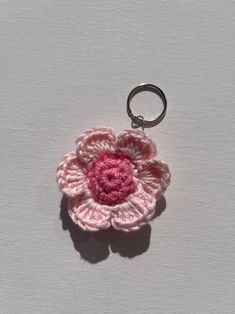 a crocheted flower keychain is shown on a white surface with a pink center