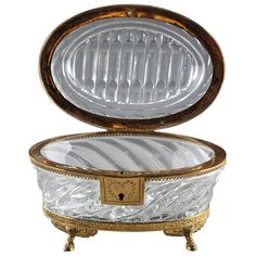 an antique looking glass box with gold trimming on the lid and bottom, sitting in front of a white background