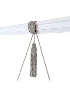 a white curtain with tassels hanging from it's end and on the side