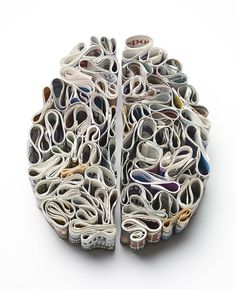 an artistically designed paper sculpture made out of magazines and newspaper strips, on a white background