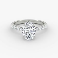 an oval cut diamond engagement ring with pave set shoulders