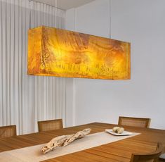 a dining room table with a large painting hanging above it