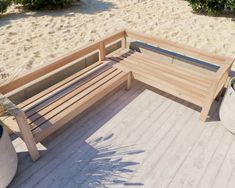 a wooden bench sitting on top of a sandy beach next to a potted plant