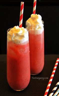 two glasses filled with drinks sitting on top of a table next to striped straws