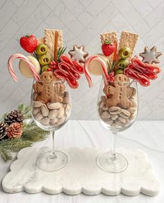 two wine glasses filled with food and candy