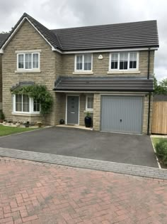 a two story brick house with garage and driveway