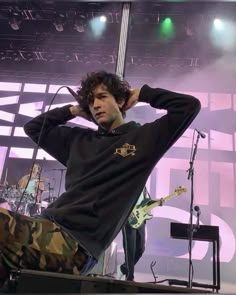 a young man sitting on top of a stage