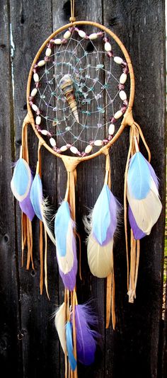 a colorful dream catcher hanging on a wooden fence