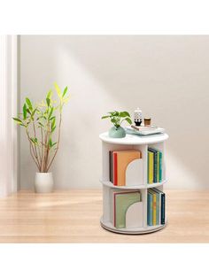 a white shelf with books on top of it next to a potted green plant