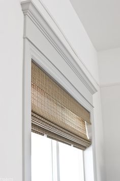 the blinds in this window are made out of bamboo and have been pulled together to make it