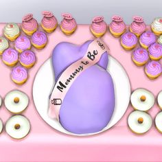 a pink table topped with lots of cupcakes