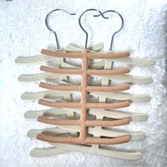 the back of a wooden hanger with multiple pairs of hooks attached to it on a white background