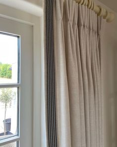 the curtains are pulled back and hung on the wall next to the window sill