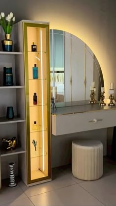 a dressing table with a mirror, stool and vases on the shelf next to it