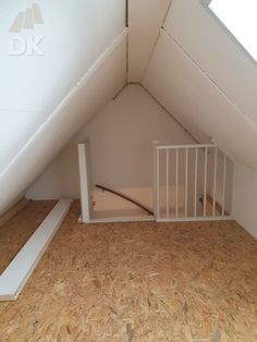 an attic with wooden floor and white railing