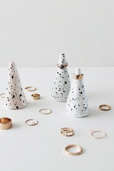 three white ceramic trees with gold rings around them and the words interest written in red