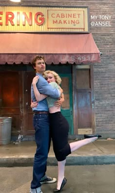 two people hugging each other in front of a building with a sign that says caring