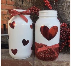 two mason jars with hearts painted on them