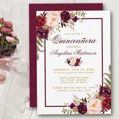 the burgundy and white floral quinceaue wedding card is next to a bouquet of flowers