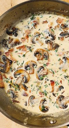 a pan filled with mushrooms and cheese on top of a wooden table