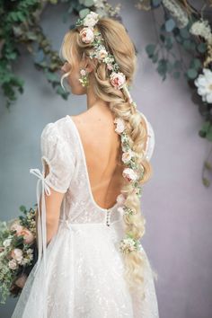 a woman with long blonde hair and flowers in her hair, wearing a white dress