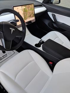 the interior of a modern car with white leather and black trims, including steering wheel