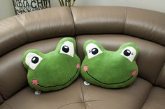 two pillows that have been placed on the back of a couch, one with eyes