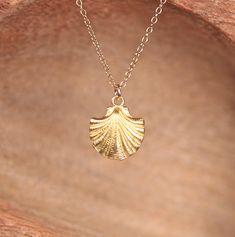 a gold necklace with a large leaf on it