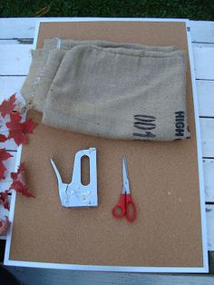 a pair of scissors sitting on top of a piece of paper next to some leaves