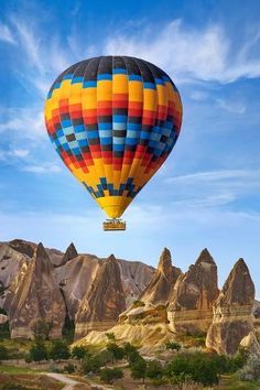 a colorful hot air balloon flying over mountains