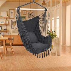 a hammock chair hanging from the ceiling in a room with wood flooring