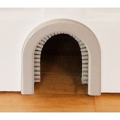 an arched window on the side of a white wall