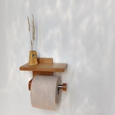 a toilet paper holder on a wooden shelf