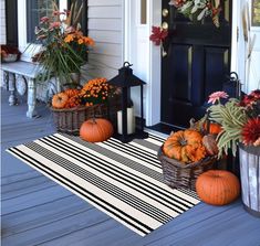 some pumpkins and gourds are sitting on the porch