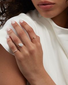 a close up of a person wearing a white shirt with a ring on her finger