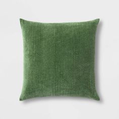 a green pillow on a white wall with the back turned to look like it is made from