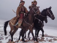 two people riding horses in the snow with other people behind them on a snowy day