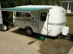 an rv parked in front of a house with a awning over the side door